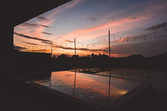 Desa Kayu pool at sunset with string lights